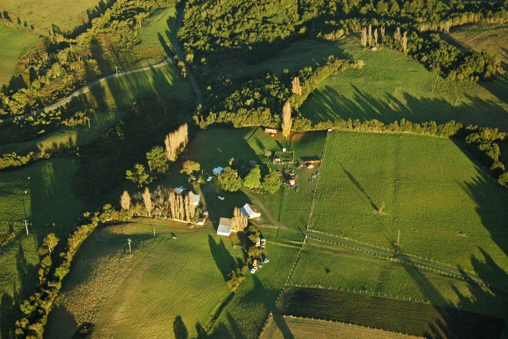 Vista aérea de campos y una casa al atardecer en la Península de Rilán, Chiloé